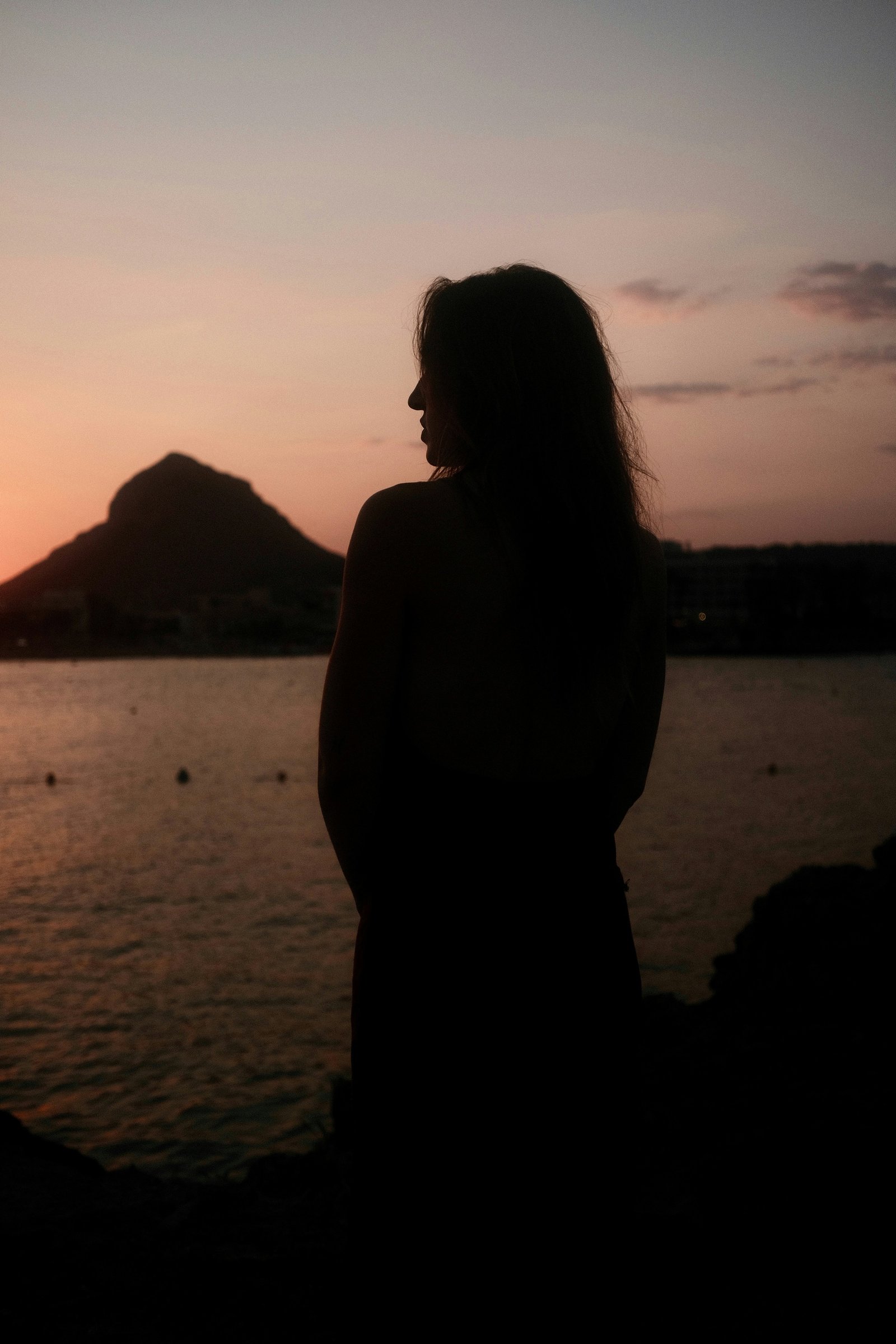 Silhouette di una donna al tramonto in riva al mare